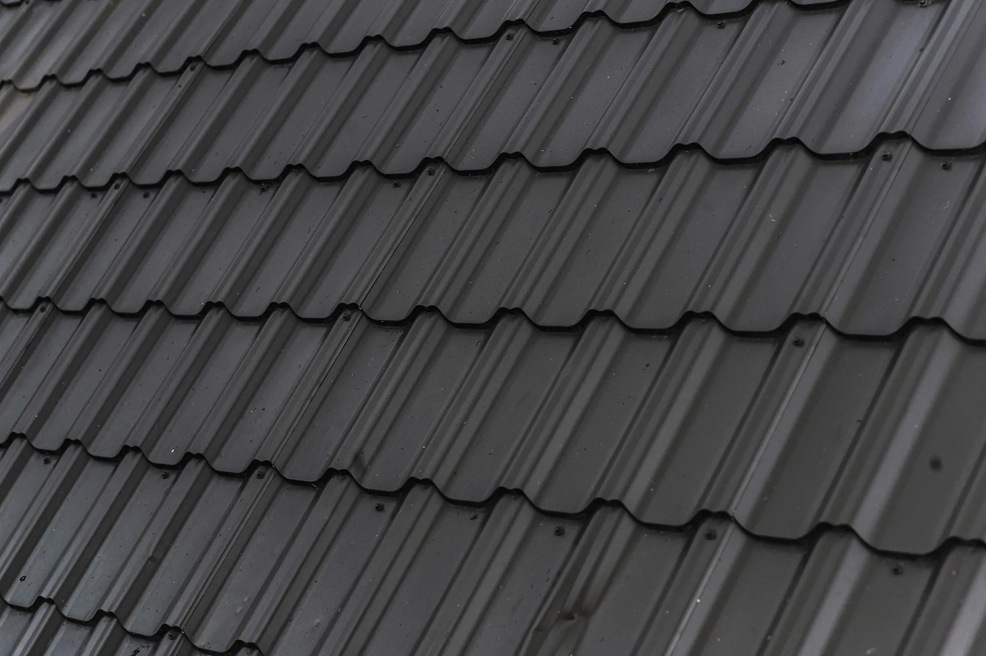 Dark gray roof tiles in long even rows