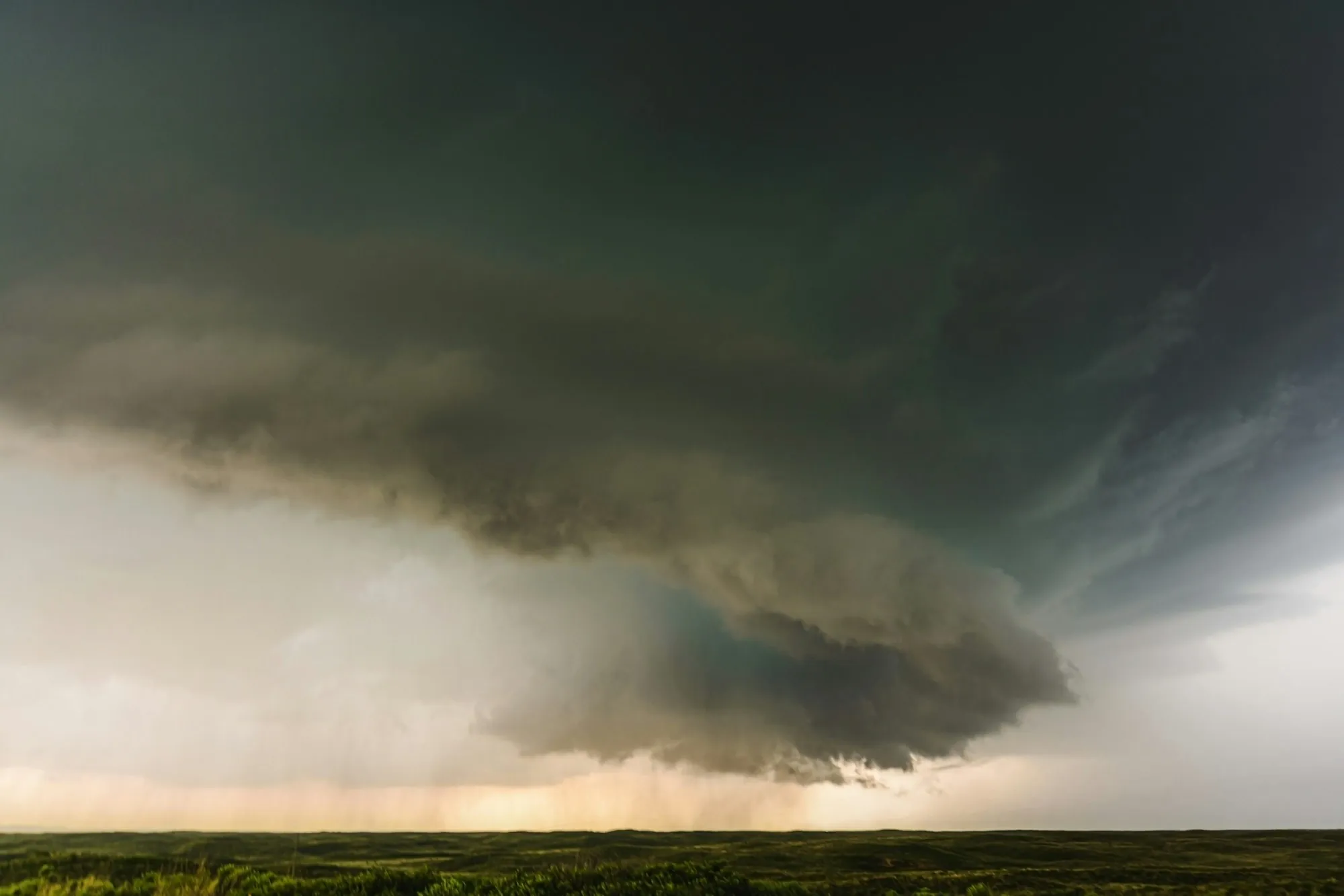 Supercell storm cloud hovering over flat open land